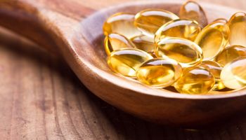 Cod liver oil omega 3 gel capsules single on wooden background