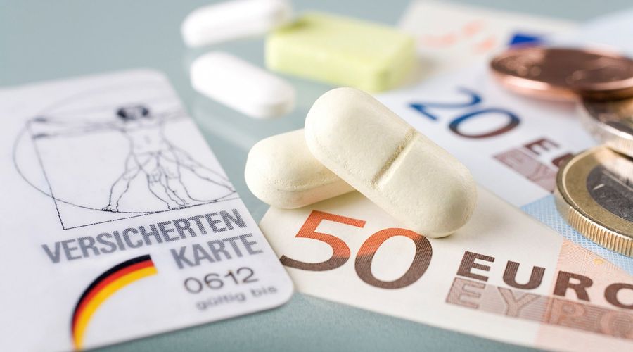 Um grande plano de um cartão de seguro da Alemanha, dinheiro e medicamentos.
