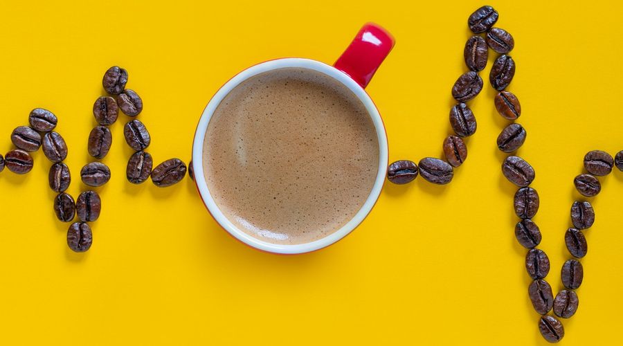 Heartbeat pulse line with red coffee cup on yellow background. Coffee Cardio Images.coffee heartbeat . Medicine and health care concept