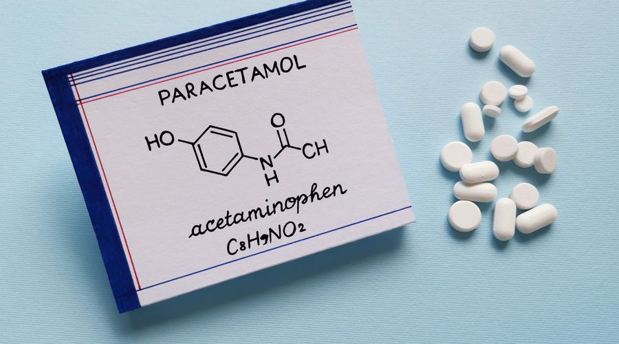 Strukturelle chemische Formel des Paracetamolmoleküls mit Tabletten und Tabletten im Hintergrund. Paracetamol oder Acetaminophen ist ein Medikament zur Behandlung von Schmerzen und Fieber und ein mildes Analgetikum.