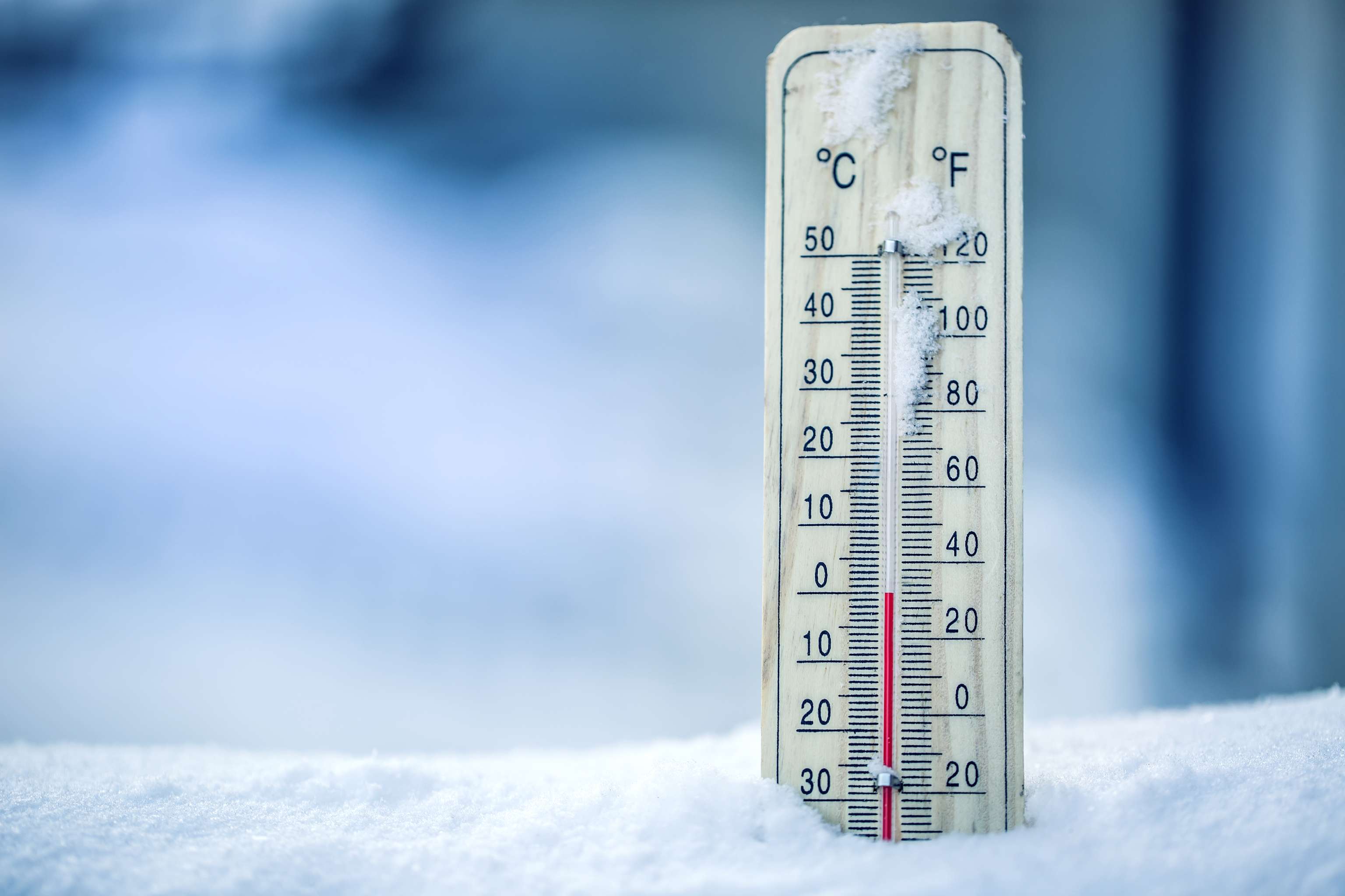 De thermometer op sneeuw geeft lage temperaturen aan in Celsius of Farenheit.