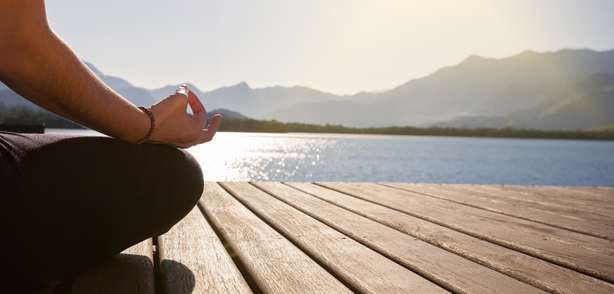 Méditation sur un ponton au bord d'un lac Médiation sur une passerelle au bord d'un lac