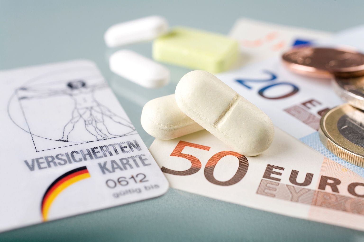 Um grande plano de um cartão de seguro da Alemanha, dinheiro e medicamentos.