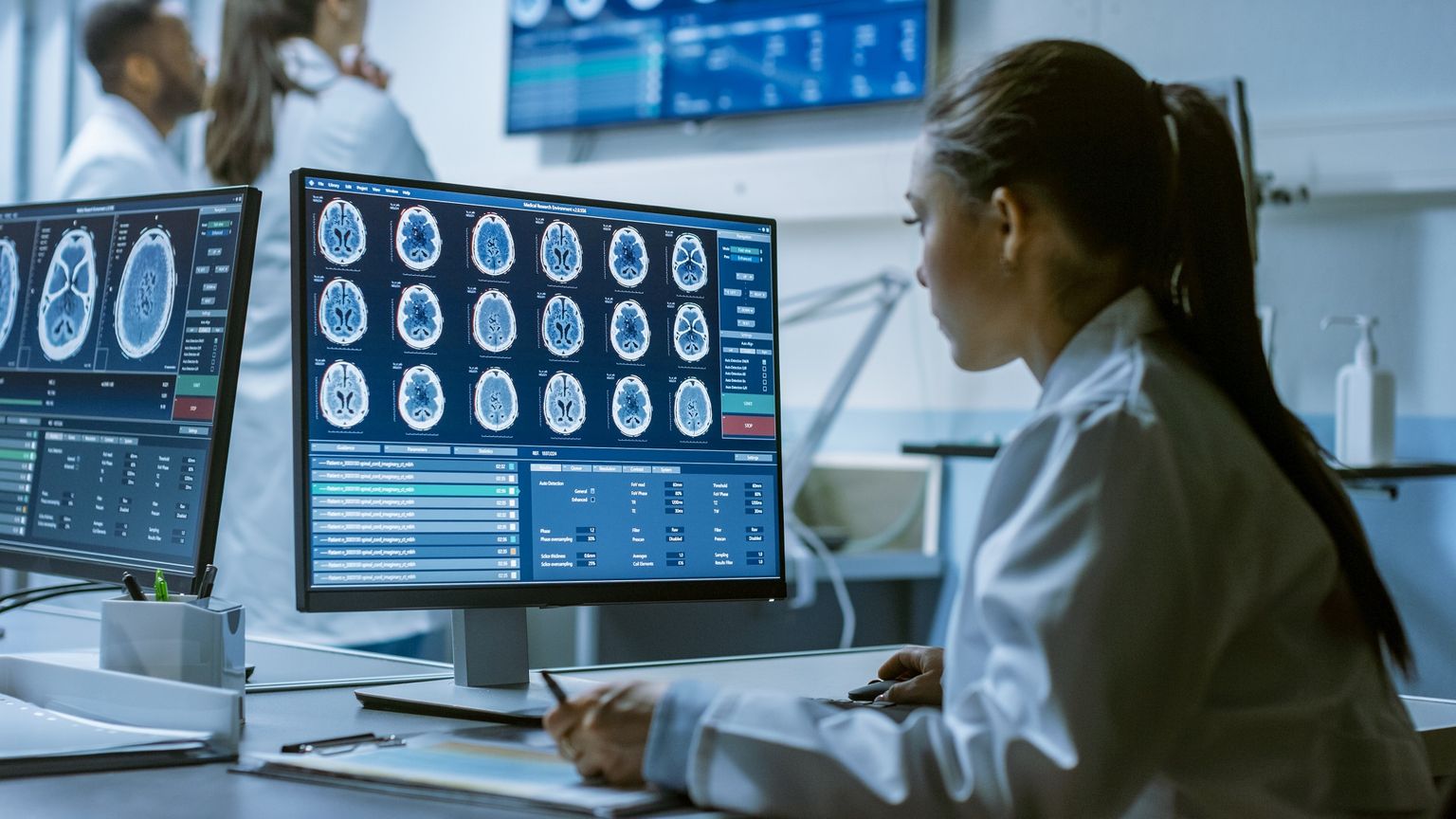 Uma cientista médica analisa as tomografias computorizadas de um cérebro.