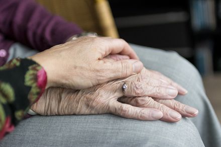 Young hand holding hand of older person