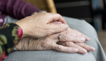 Mão jovem segurando a mão de uma pessoa mais velha