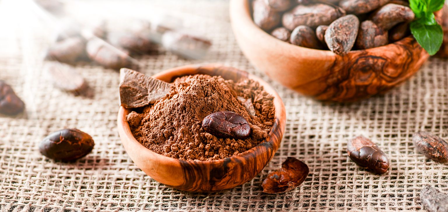Nahaufnahme von Kakaobohnen und Kakaopulver
