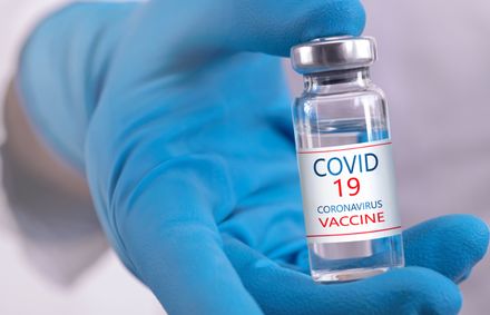 Um médico tem uma vacina COVID-19 na mão.