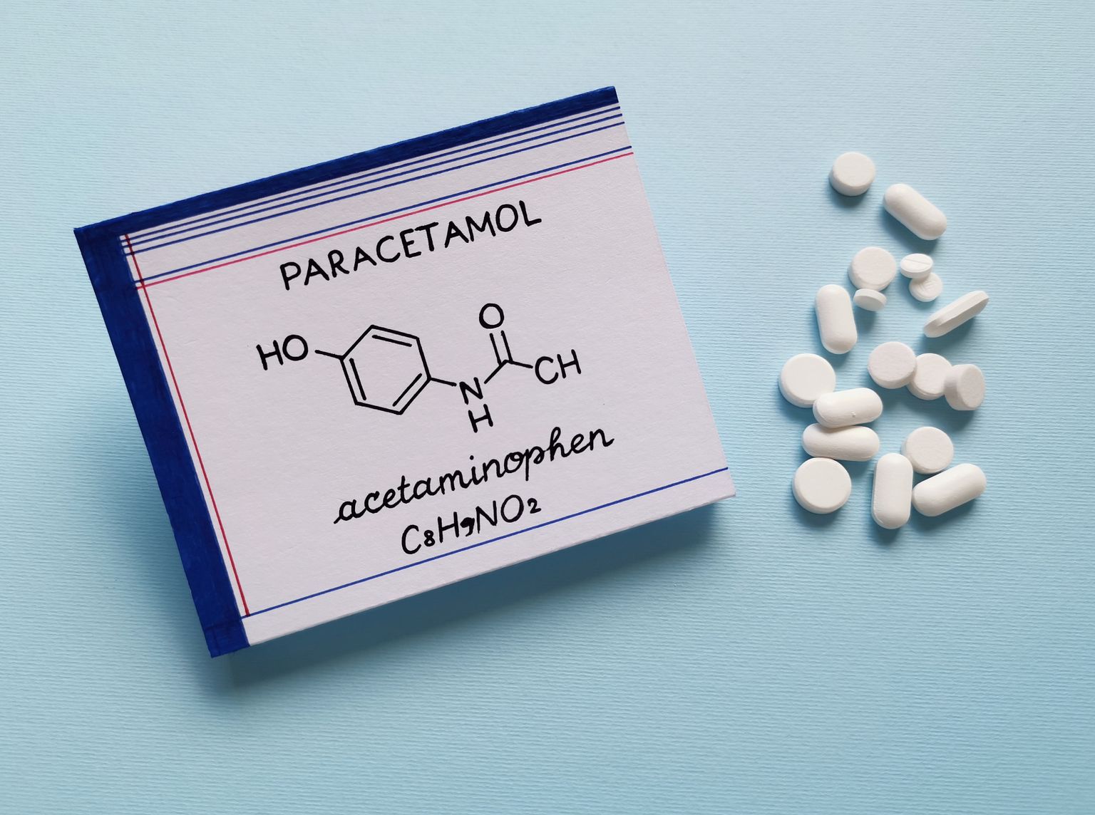 Formula chimica strutturale della molecola di acetaminofene con pastiglie e compresse sullo sfondo. Il paracetamolo o acetaminofene è un farmaco usato per trattare il dolore e la febbre ed è un leggero analgesico.