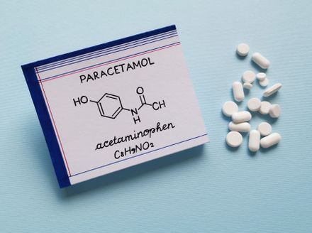 Fórmula química estrutural de molécula de acetaminofeno com comprimidos e pastilhas no fundo. Paracetamol ou acetaminofeno é um medicamento usado para tratar a dor e a febre e é um analgésico suave.