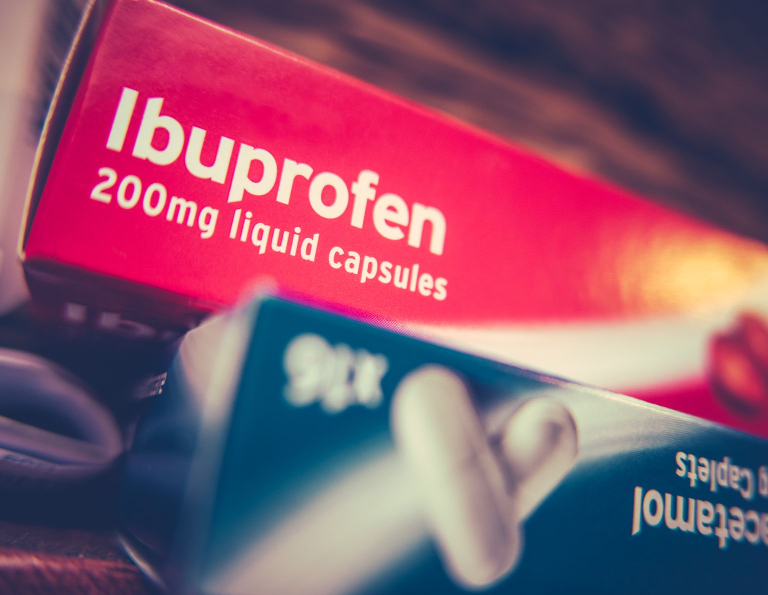 Scatola di antidolorifici con prescrizione ibuprofene e paracetamolo su un armadio a casa