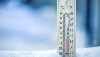 De thermometer op sneeuw geeft lage temperaturen aan in Celsius of Farenheit.